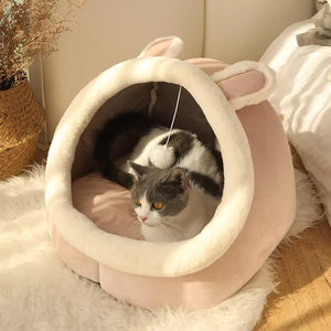 Pat igloo roz pentru pisici, cu urechi de iepuraș și jucărie pompon, pisică odihnindu-se în interior
